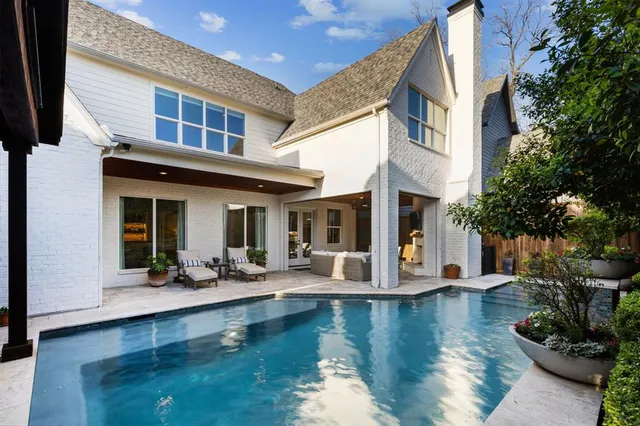 a view of a house with pool lawn chairs