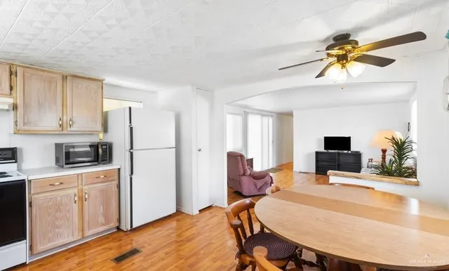 a living room with stainless steel appliances furniture a fireplace and a flat screen tv