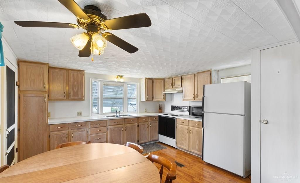 128 Apache Drive Harlingen, TX 78552 - Photo 4 of 17 a kitchen with a refrigerator a sink dishwasher a stove and a microwave oven