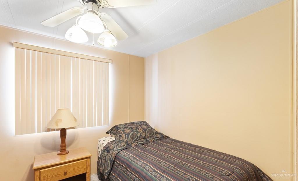 128 Apache Drive Harlingen, TX 78552 - Photo 6 of 17 a bedroom with a bed and a chandelier