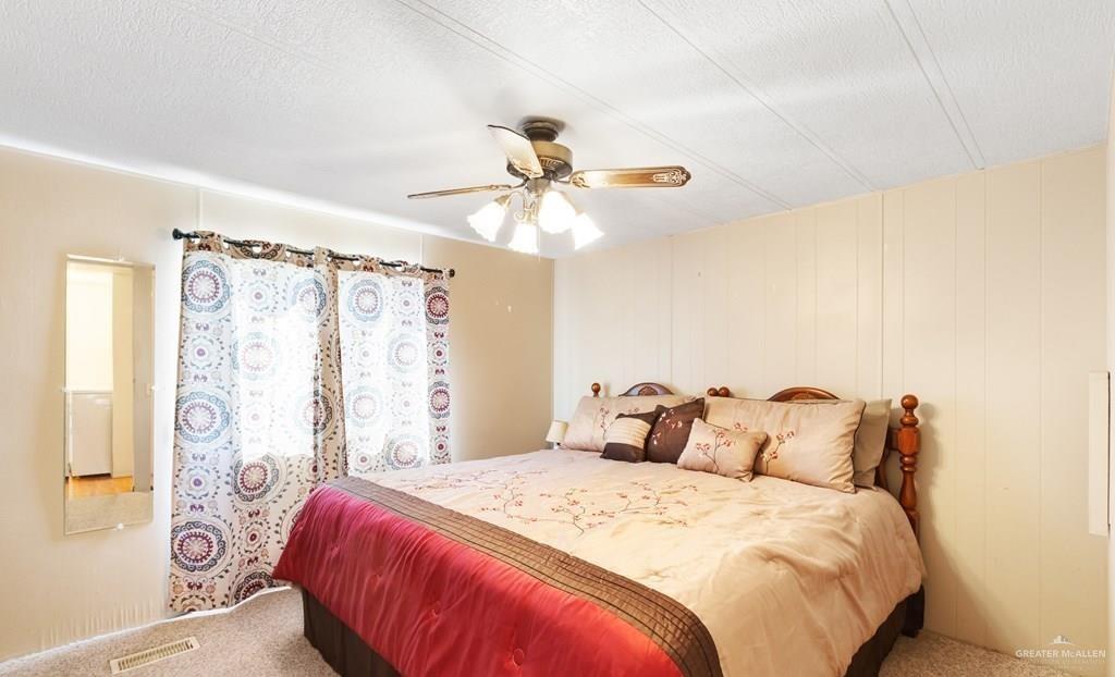 128 Apache Drive Harlingen, TX 78552 - Photo 10 of 17 a bedroom with a bed and a chandelier