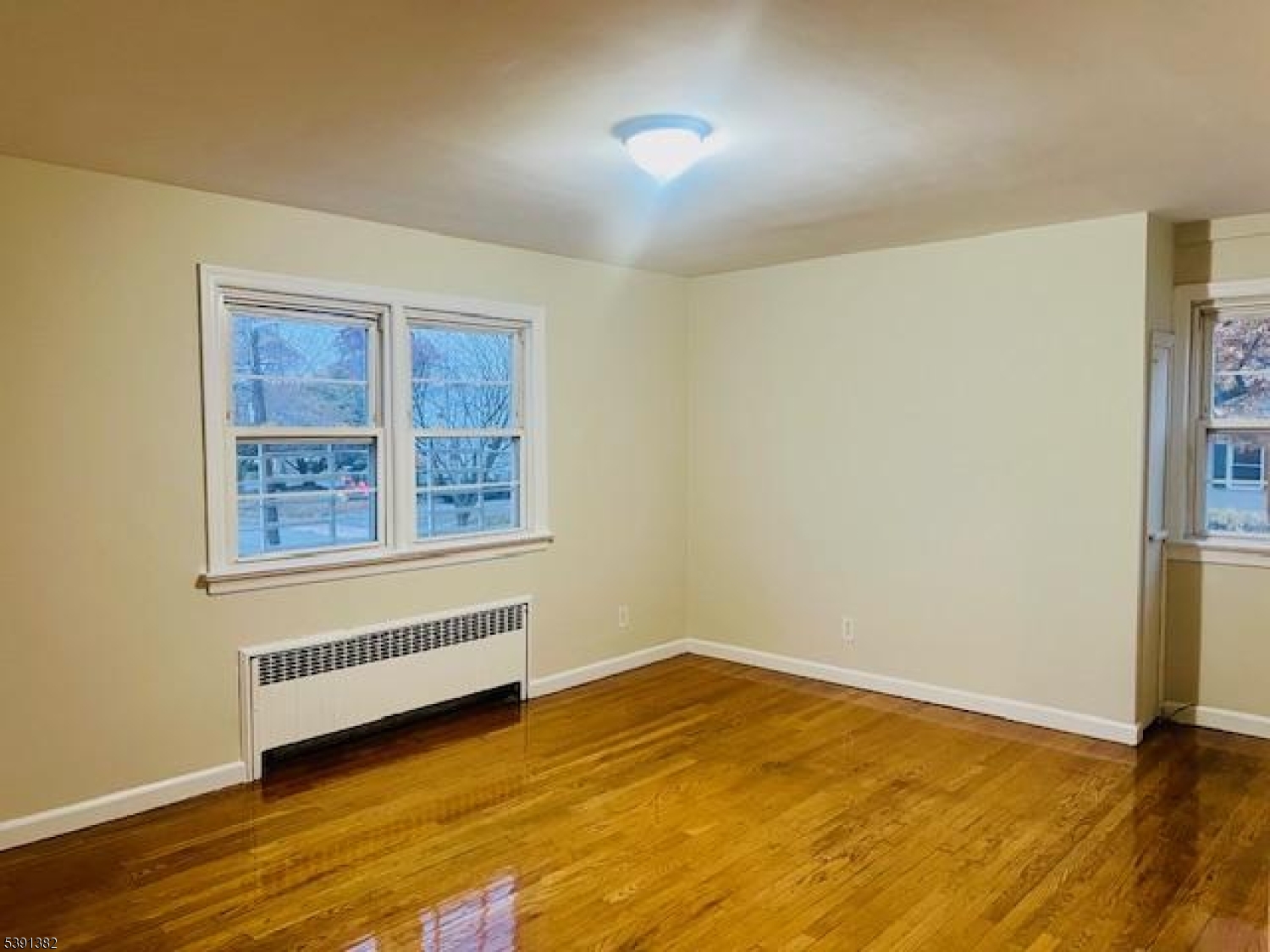 3 Freeman Place Nutley, NJ 07110 - Photo 5 of 10 a view of an empty room with wooden floor and a window