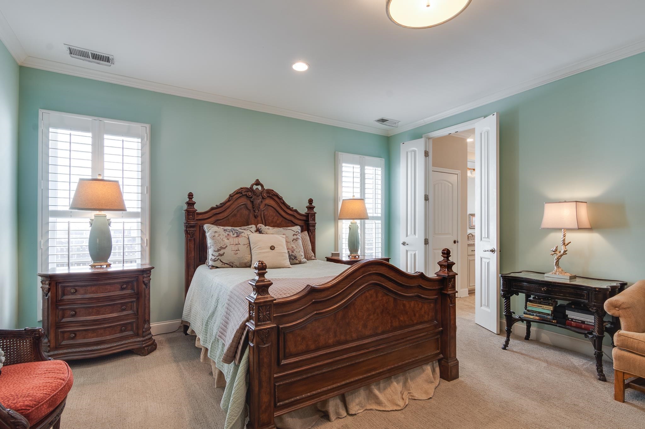 Bedroom featuring light colored carpet, crown molding, recessed lighting, and ensuite bathroom
