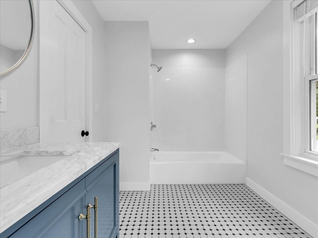 186 Main Street, Unit 2 Wayland, MA 01778 - Photo 12 of 41 a bathroom with a granite countertop sink a toilet a mirror and shower