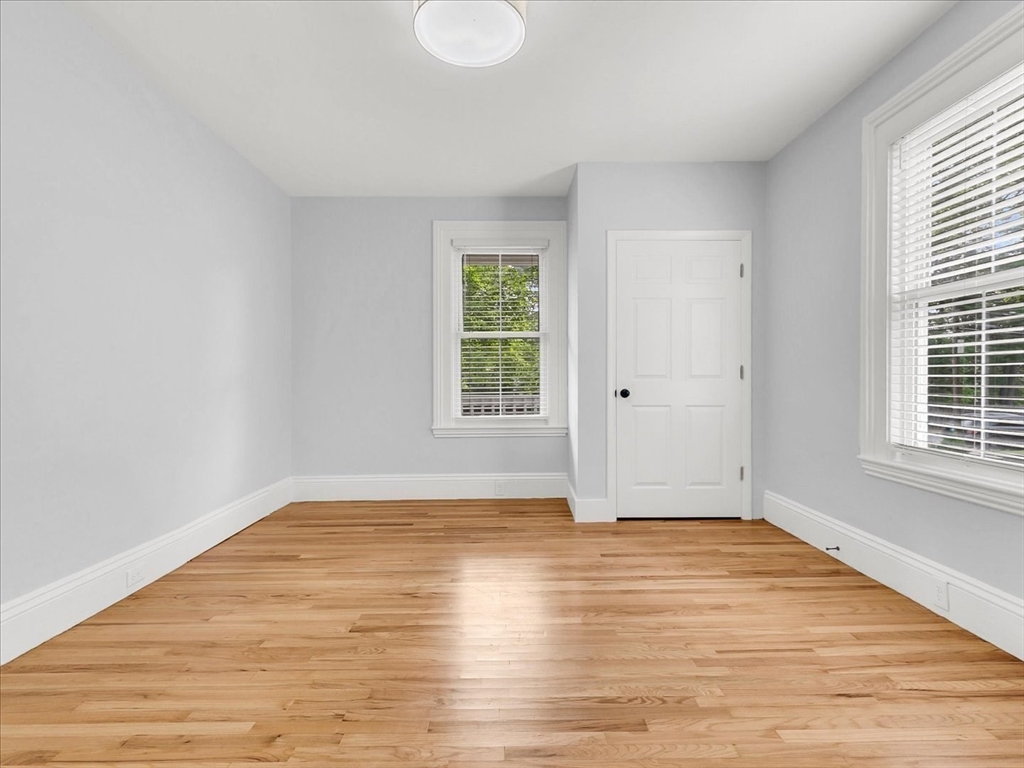 186 Main Street, Unit 2 Wayland, MA 01778 - Photo 20 of 41 a view of an empty room with wooden floor and a window
