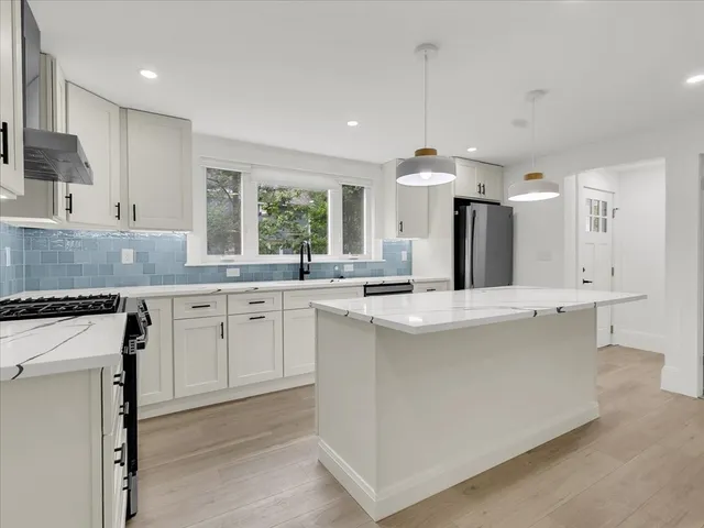 a kitchen with kitchen island a sink stove and refrigerator