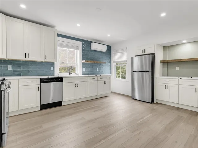 a kitchen with stainless steel appliances a refrigerator sink and cabinets
