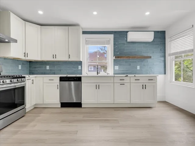 a kitchen with stainless steel appliances granite countertop a stove a sink and a microwave