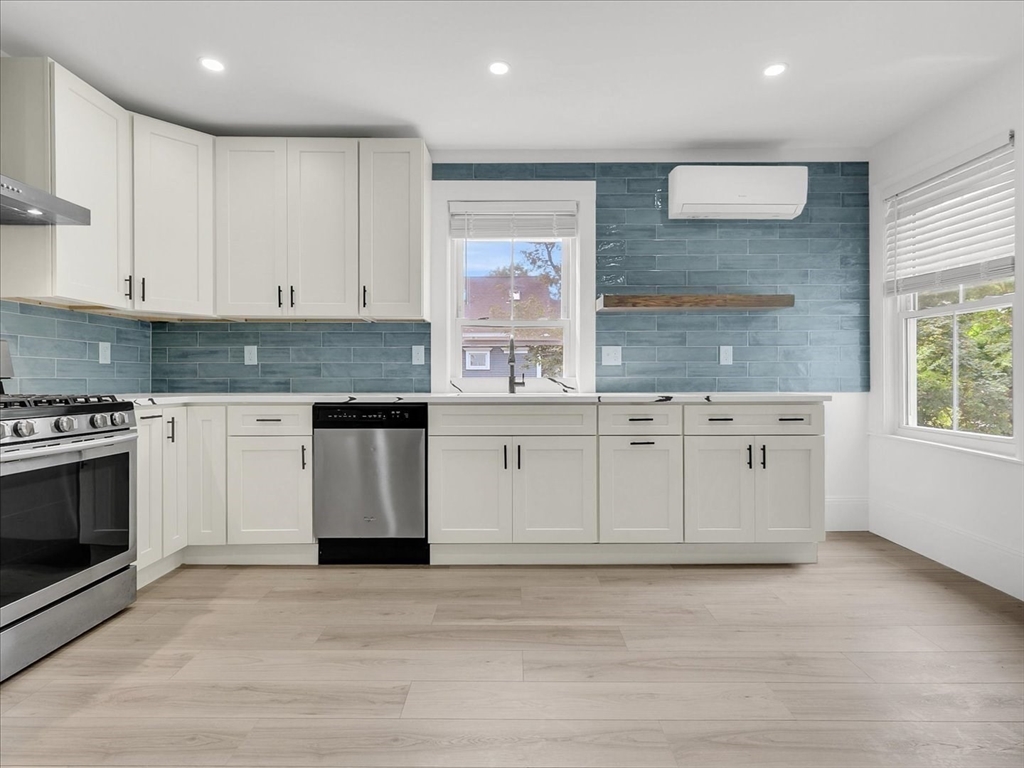 186 Main Street, Unit 2 Wayland, MA 01778 - Photo 22 of 41 a kitchen with stainless steel appliances granite countertop a stove a sink and a microwave