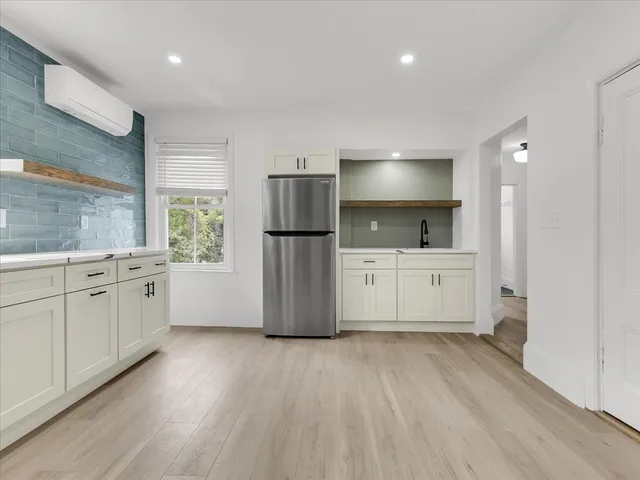 a kitchen with a white cabinets and refrigerator
