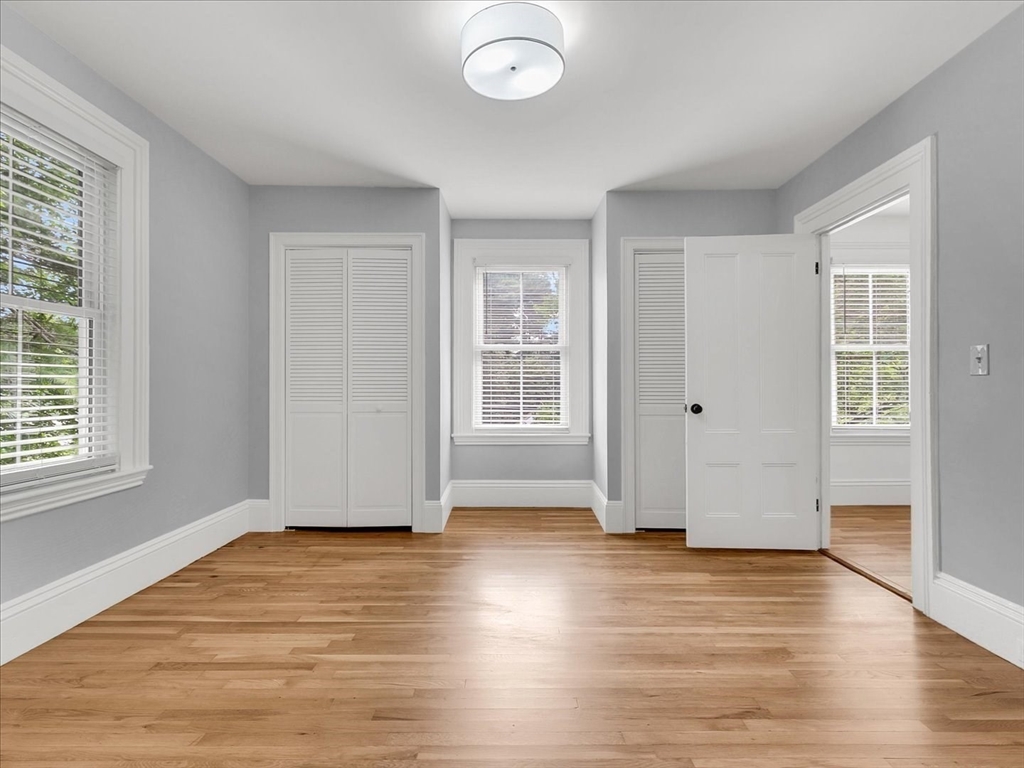 186 Main Street, Unit 2 Wayland, MA 01778 - Photo 25 of 41 an empty room with wooden floor and windows