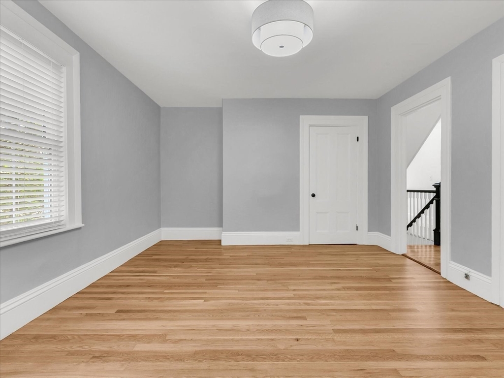 186 Main Street, Unit 2 Wayland, MA 01778 - Photo 30 of 41 a view of an empty room with wooden floor and a window