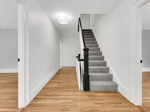 a view of a hallway with wooden floor and entryway