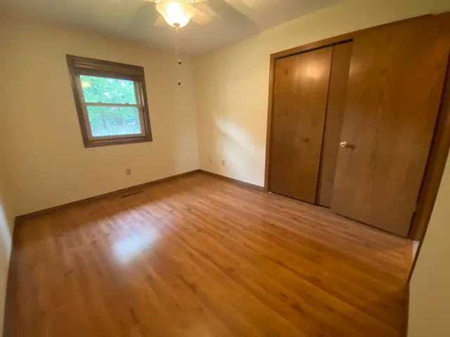 a view of a livingroom with a ceiling fan hardwood floor and a ceiling fan