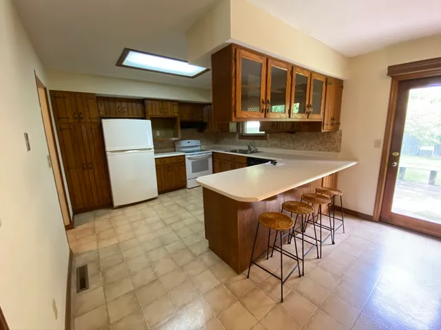 a kitchen with a table chairs sink and cabinets