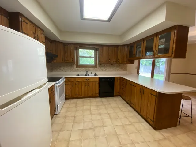 a kitchen with a stove top oven cabinets and a refrigerator