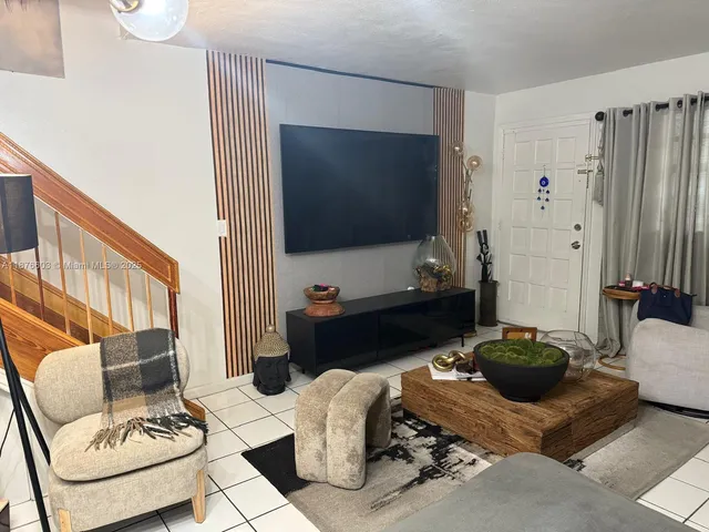 a living room with furniture a flat screen tv and a large window