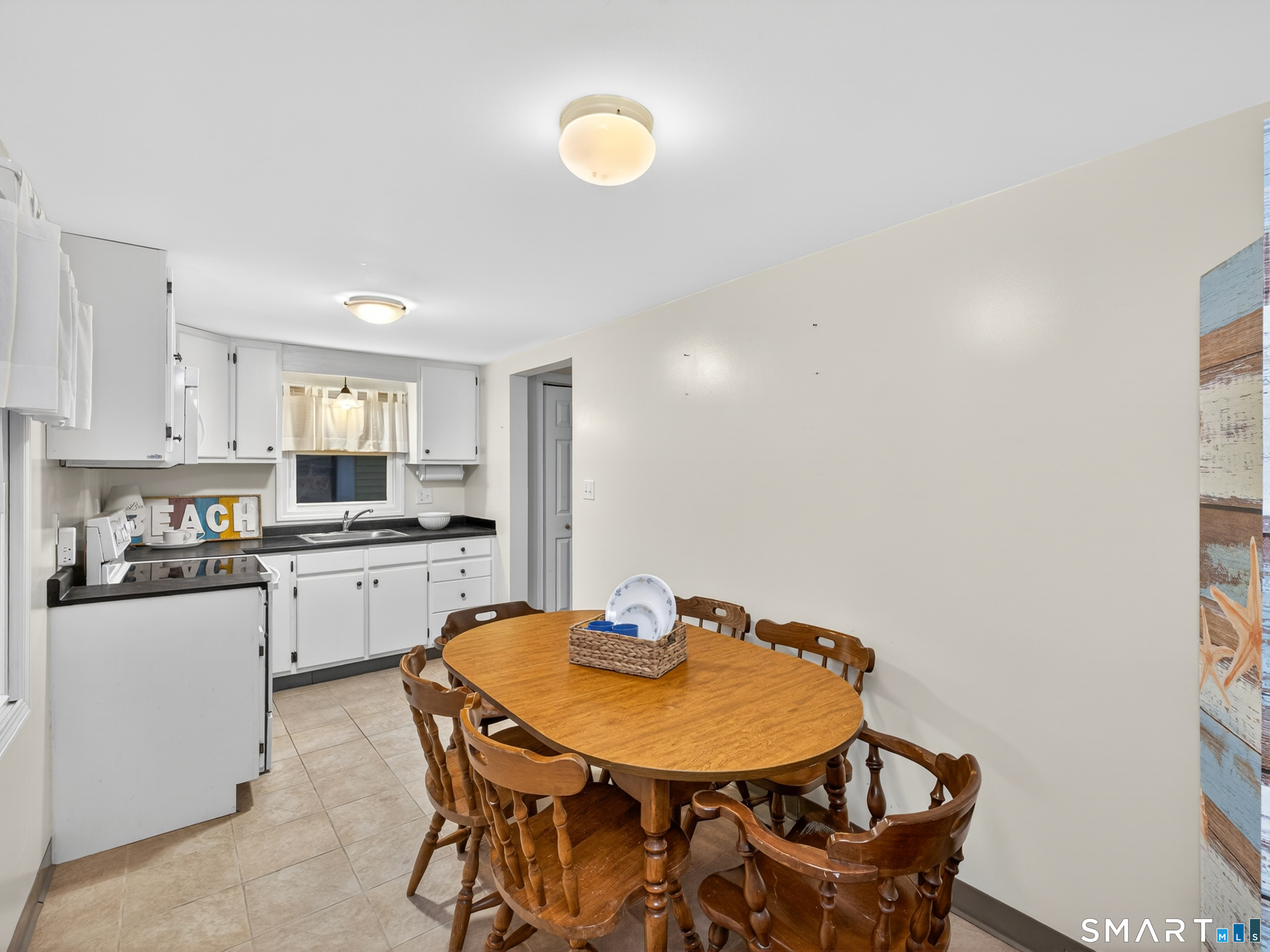 31 Old Colony Road Old Lyme, CT 06371 - Photo 31 of 38 a kitchen with a dining table chairs and white cabinets