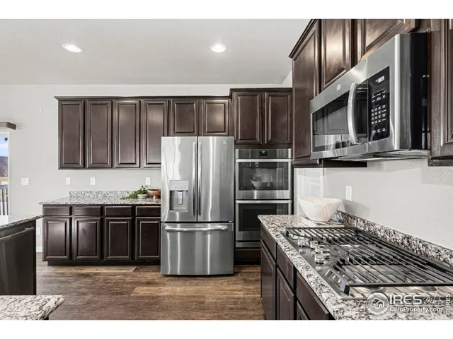 a kitchen with granite countertop stainless steel appliances and wooden cabinets
