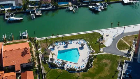 an aerial view of a swimming pool with lawn chairs and plants