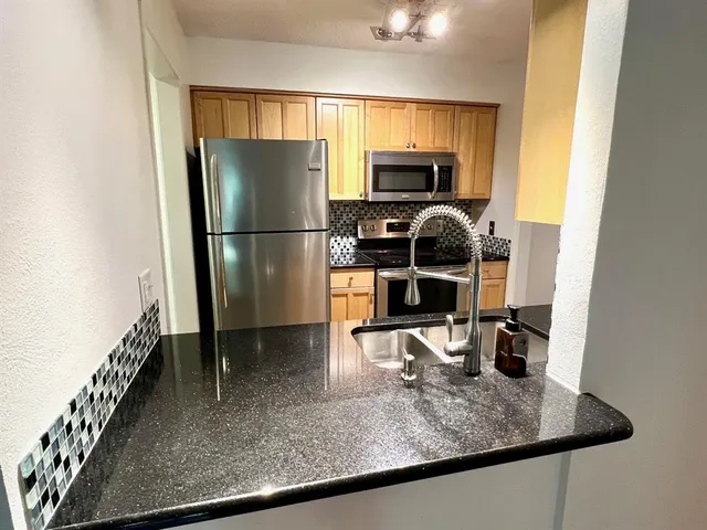 a kitchen with a refrigerator sink and stove