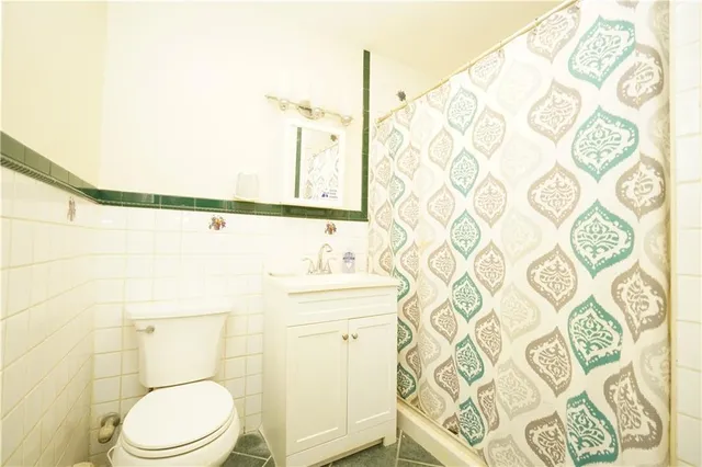a bathroom with a toilet and a shower curtain
