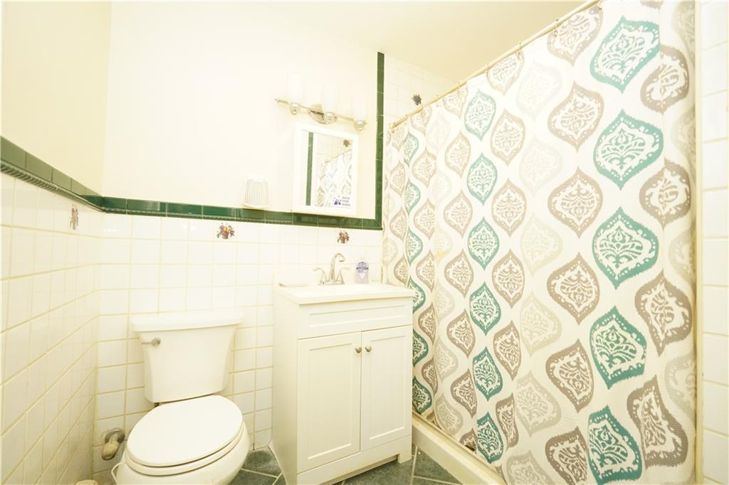 232 12th Street Brooklyn, NY 11215 - Photo 6 of 15 a bathroom with a toilet and a shower curtain