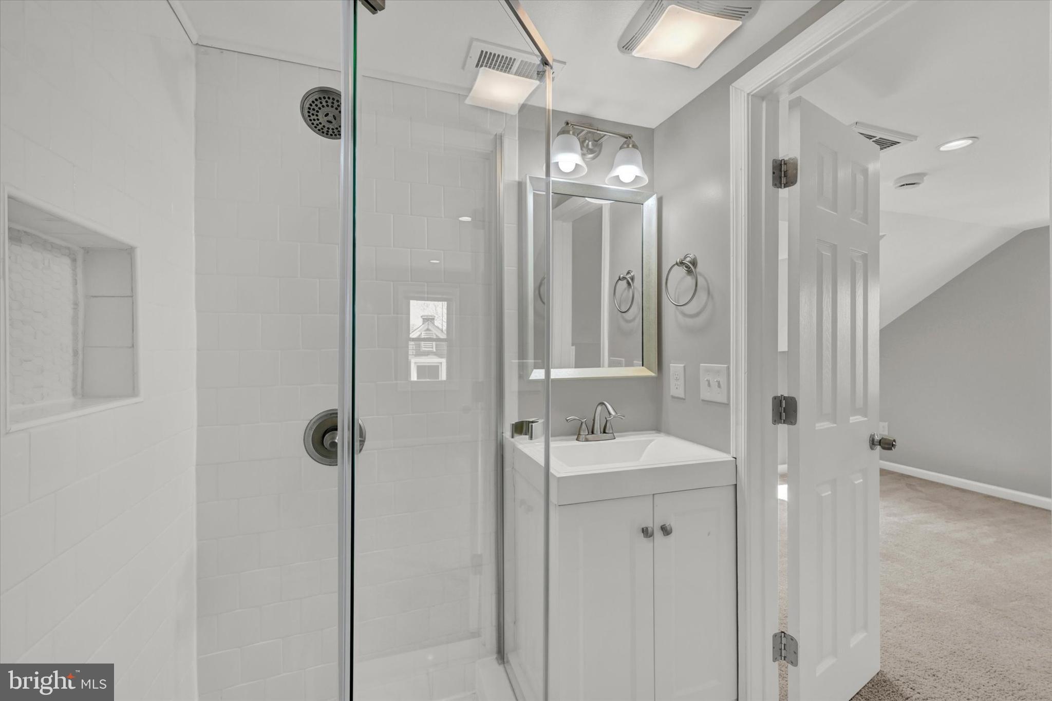 4604 Ridge Road Baltimore, MD 21236 - Photo 20 of 30 a bathroom with a shower a sink and mirror