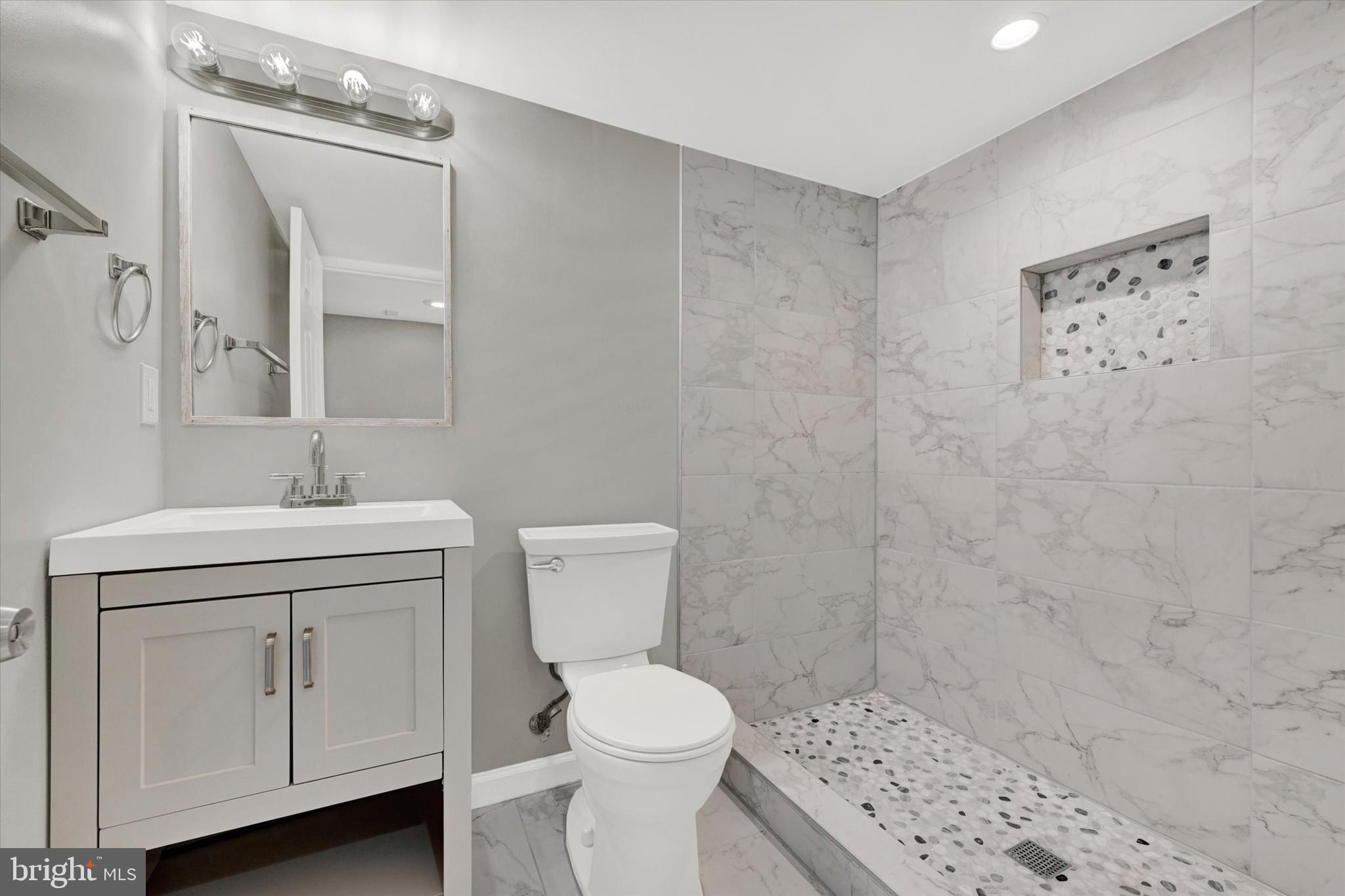 4604 Ridge Road Baltimore, MD 21236 - Photo 24 of 30 a bathroom with a sink a toilet and a mirror