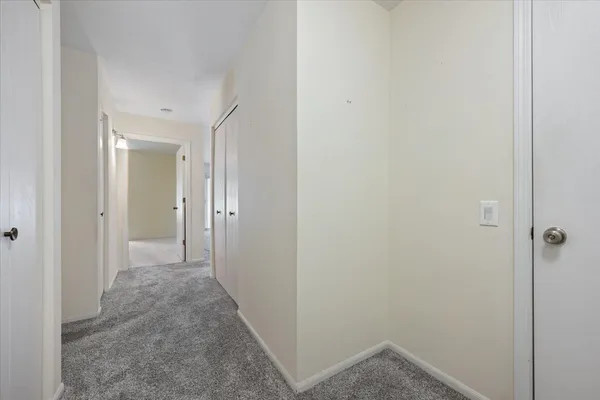 a view of a hallway with closet and wooden floor