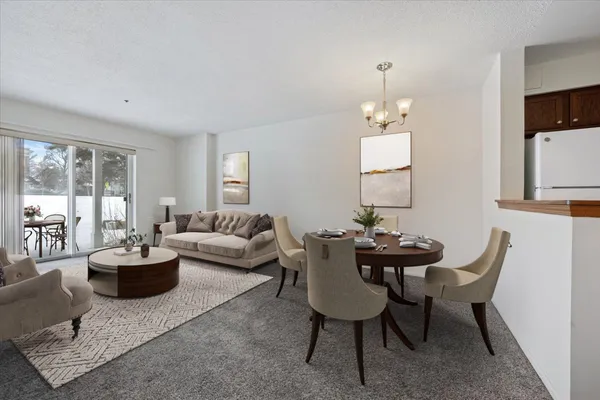 a living room with furniture a large window and a dining table