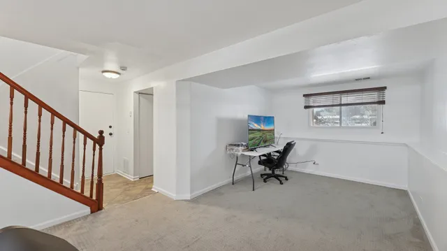 a view of a workspace with furniture and a window