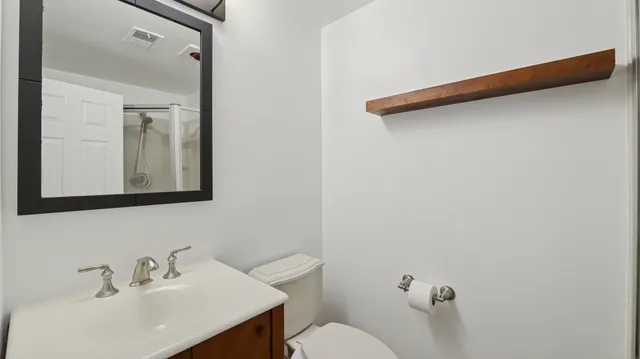 a bathroom with a sink mirror and toilet