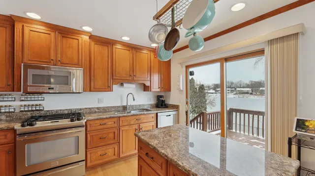 a kitchen with stainless steel appliances granite countertop a stove top oven a sink with granite countertops and cabinets