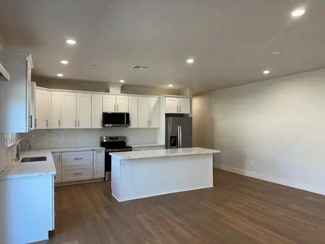 a kitchen with stainless steel appliances granite countertop a refrigerator sink and cabinets