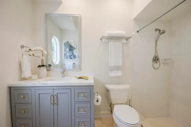 a bathroom with a sink a toilet and shower