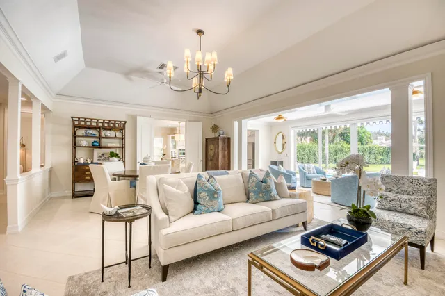 a living room with furniture chandelier and a large window
