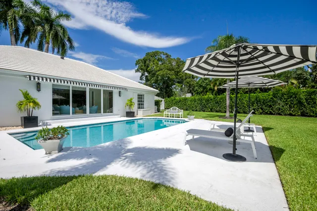 a view of a house with a swimming pool and a yard