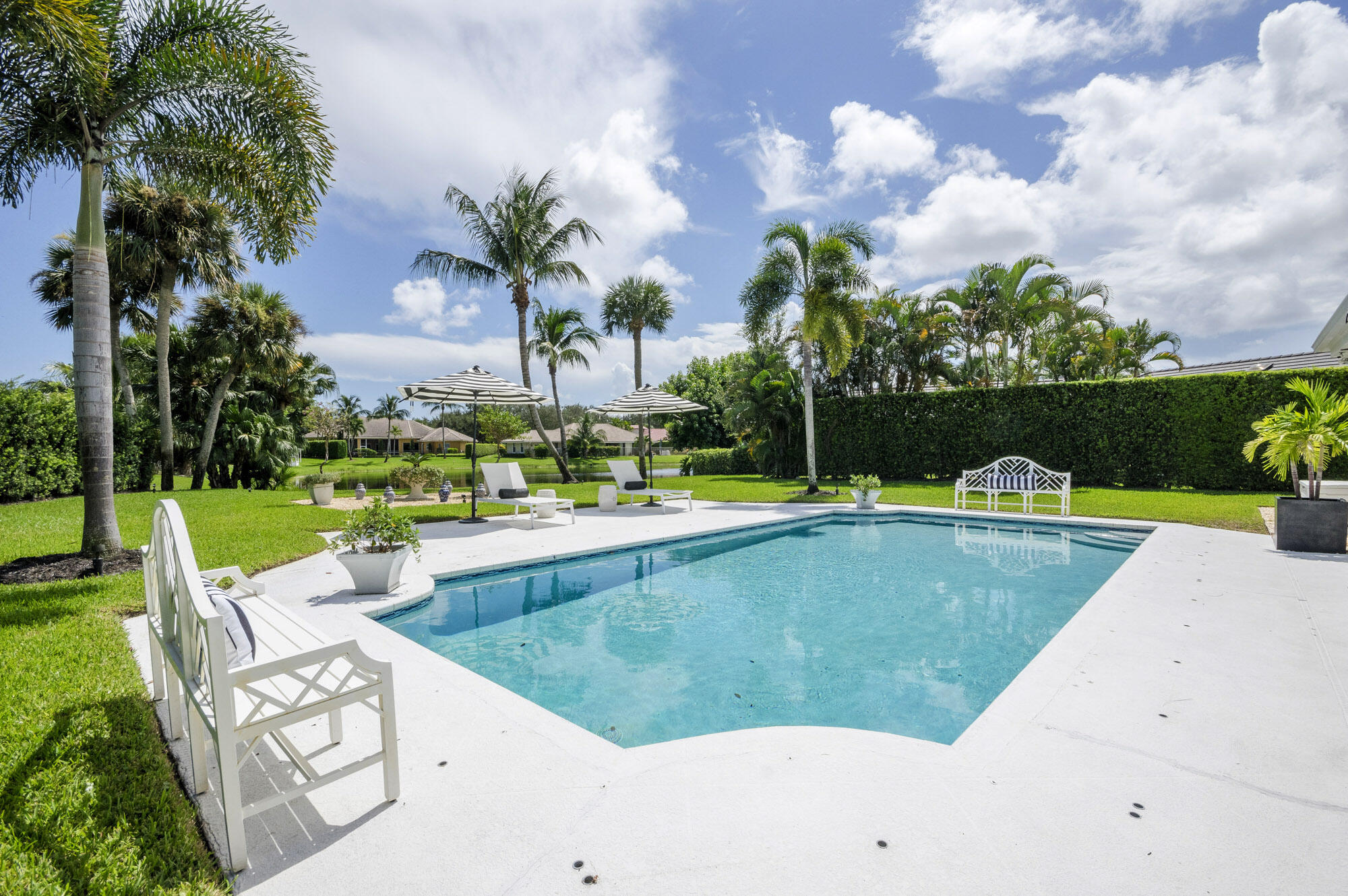 10182 Southeast Acorn Way Jupiter, FL 33469 - Photo 29 of 38 a view of a swimming pool and lounge chairs in back yard of the house