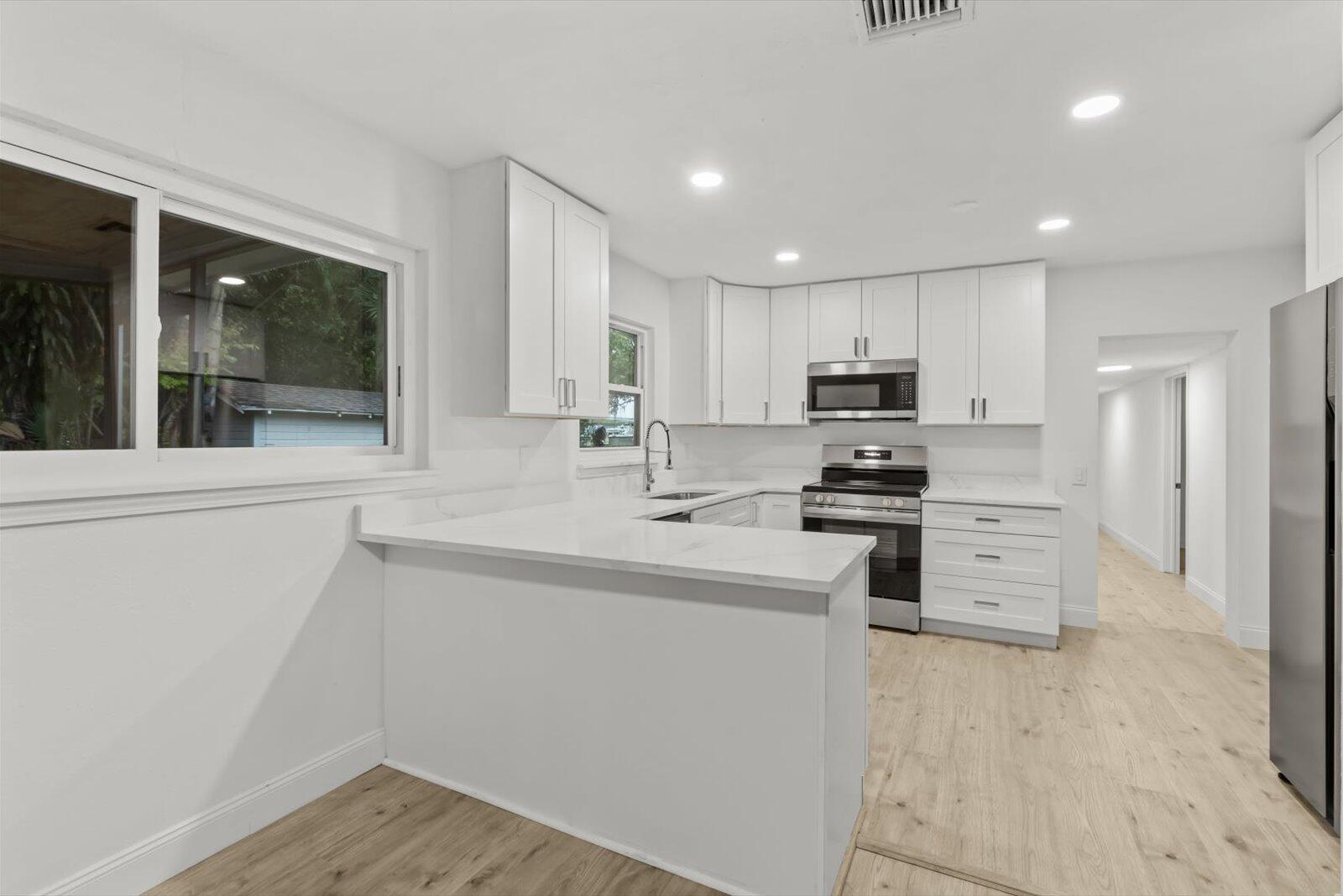 603 Southwest 14th Street Okeechobee, FL 34974 - Photo 13 of 41 a kitchen with white cabinets and appliances