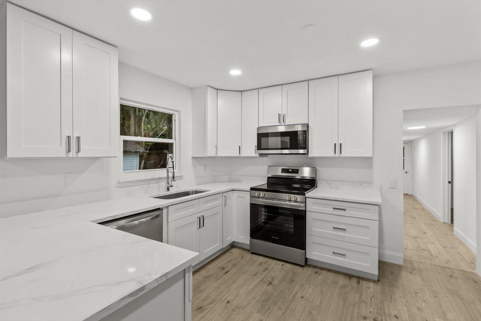 603 Southwest 14th Street Okeechobee, FL 34974 - Photo 14 of 41 a kitchen with stainless steel appliances granite countertop a sink stove and microwave