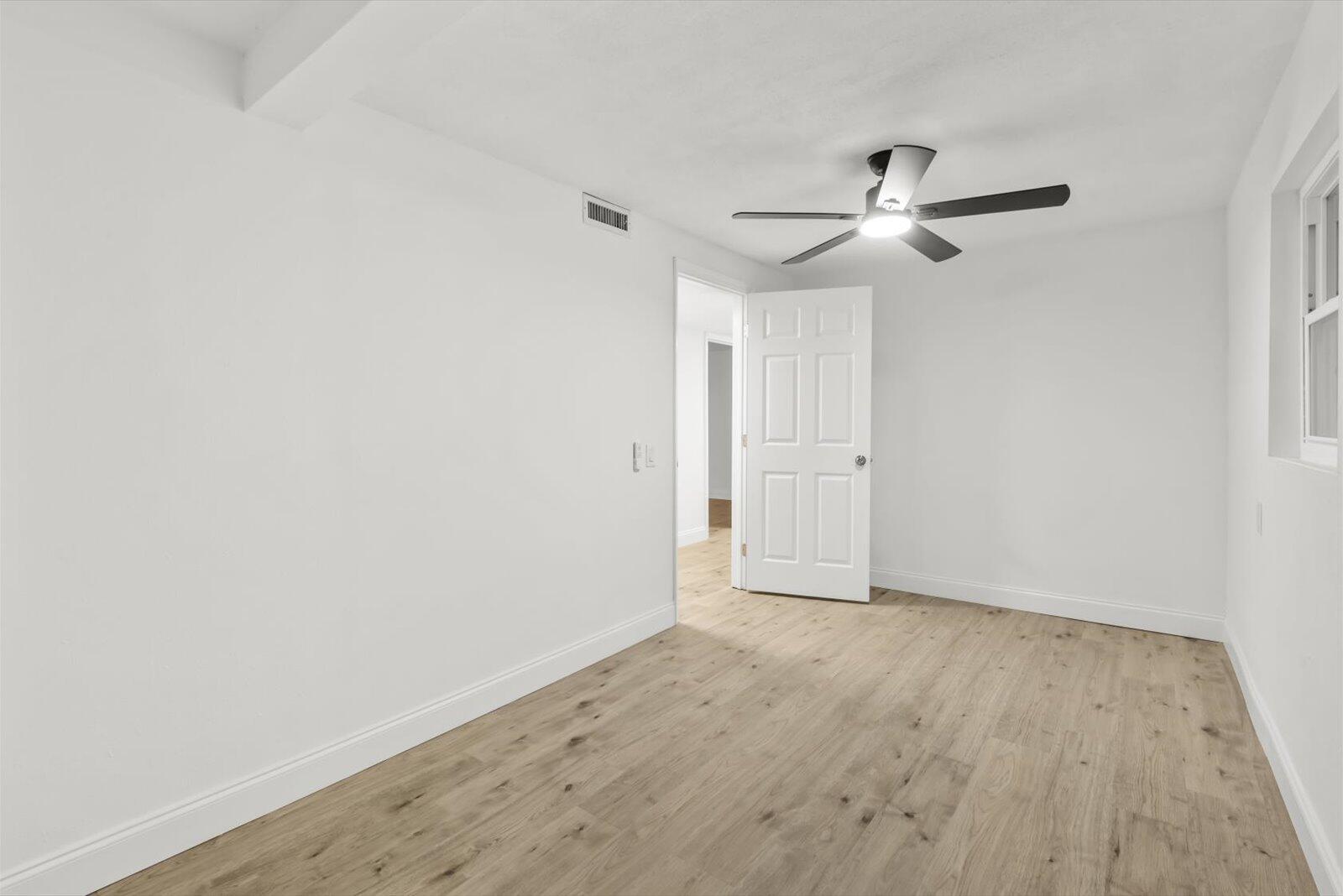603 Southwest 14th Street Okeechobee, FL 34974 - Photo 27 of 41 an empty room with wooden floor ceiling fan and window