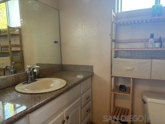 944 Maya Street Spring Valley, CA 91977 - Photo 15 of 20 a bathroom with a granite countertop sink and a mirror