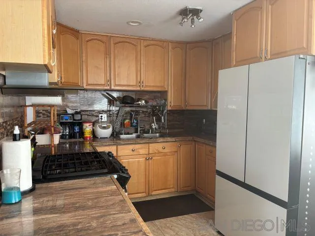 944 Maya Street Spring Valley, CA 91977 - Photo 9 of 20 a kitchen with stainless steel appliances granite countertop a refrigerator sink and cabinets