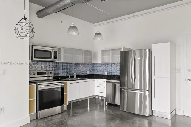 a kitchen with stainless steel appliances granite countertop a stove and a refrigerator
