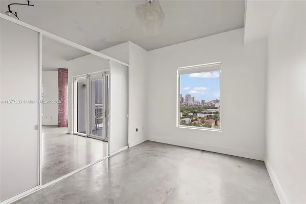 an empty room with windows and closet