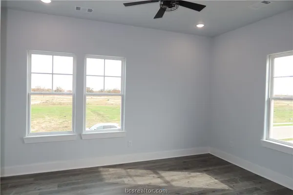 an empty room with a window and ceiling fan