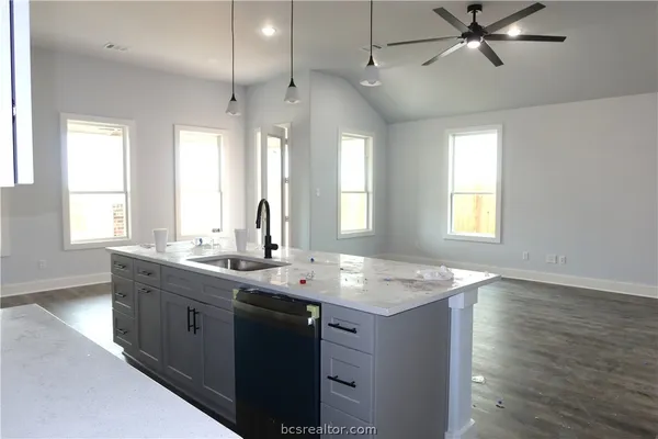 a kitchen with stainless steel appliances granite countertop a sink stove and wooden floor