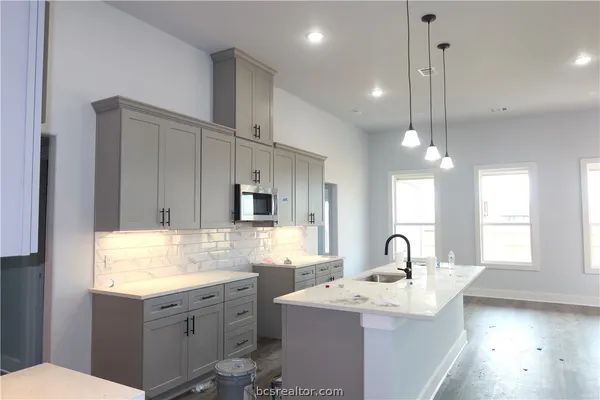 a kitchen with sink stove and microwave