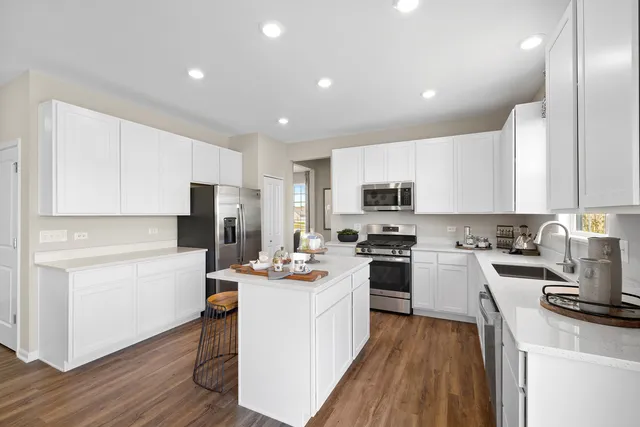 a kitchen with a sink a counter top space stainless steel appliances and cabinets